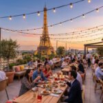 Vue panoramique d'un restaurant en rooftop à Paris au coucher du soleil. Des convives dînent avec la Tour Eiffel illuminée.